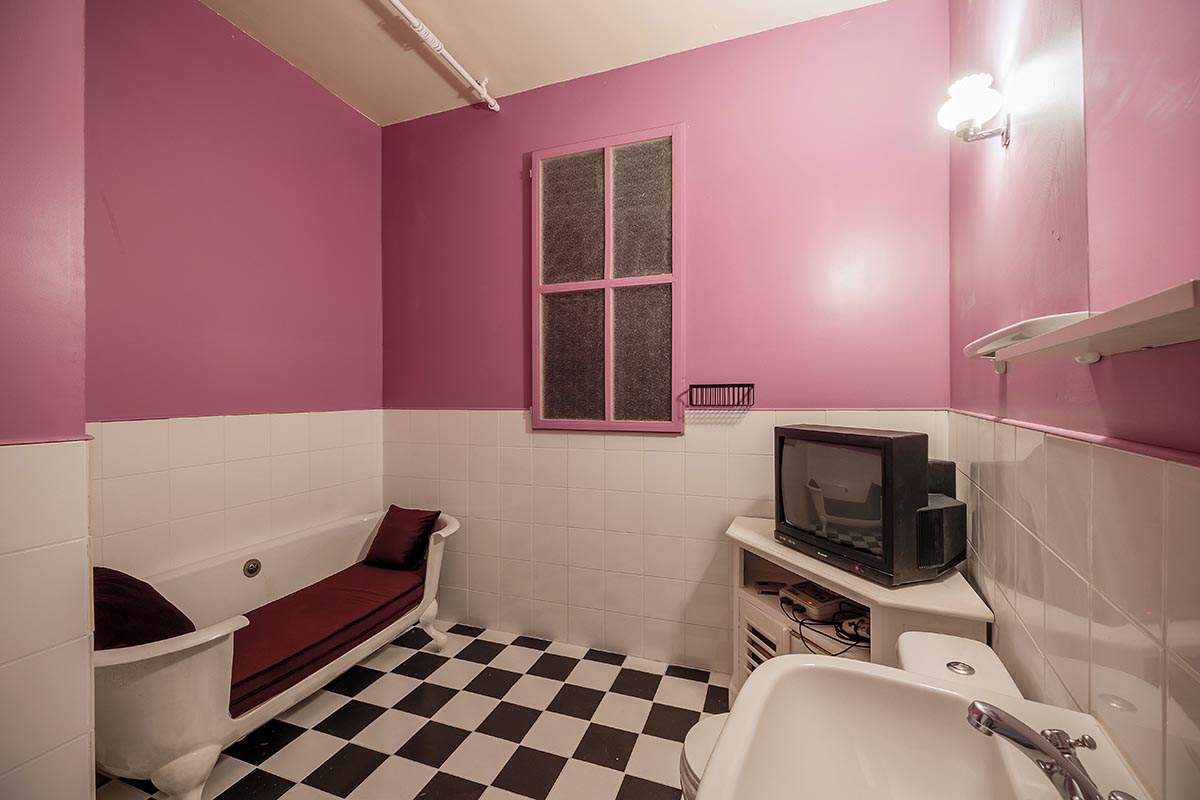 Photo 5 de l'intérieur de notre salon Sitcom 12 (pour 12 personnes) - Focus sur la salle de bain, avec une baignoire retravaillée en mode banquette pour pouvoir jouer à une console de retrogaming
