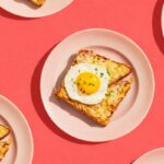 Tartines de brunch au jambon et fromage gratiné, surmontées d’un œuf au plat au jaune coulant et de ciboulette, servies avec une salade verte assaisonnée. 🍳🥗